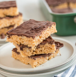 peanut butter Rice Krispie treats with chocolate stacked tall on a plate