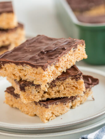 peanut butter Rice Krispie treats with chocolate stacked tall on a plate