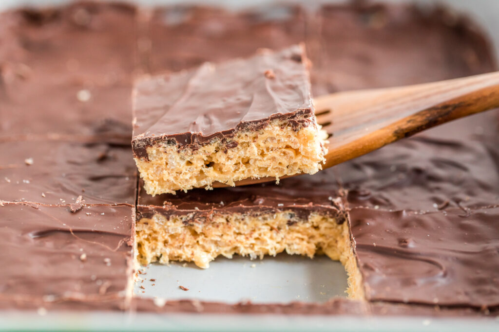 wooden spatula lifting chocolate Rice Krispie treat with peanut butter