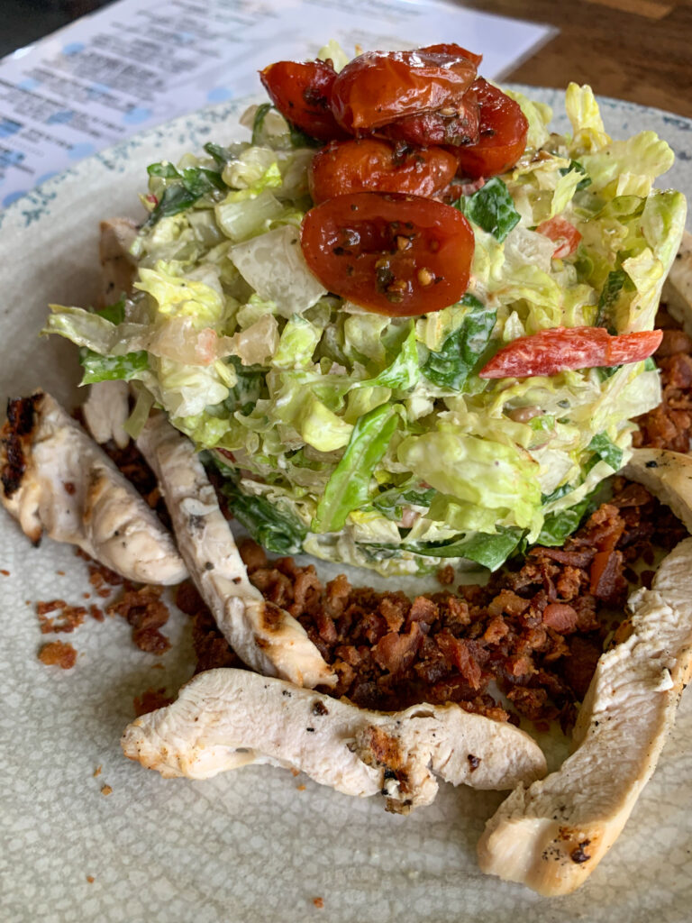 Hall's chop salad on white plate at Rita's Seaside Grille in Folly Beach girls getaway