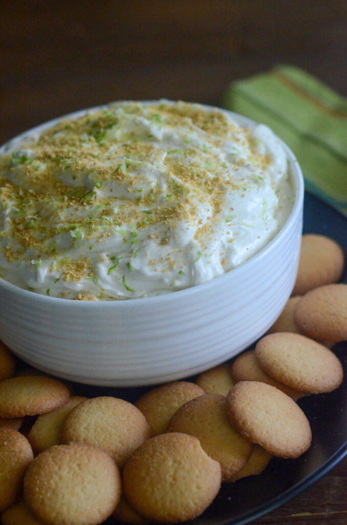 key lime pie dip in white bowl with vanilla wafers around