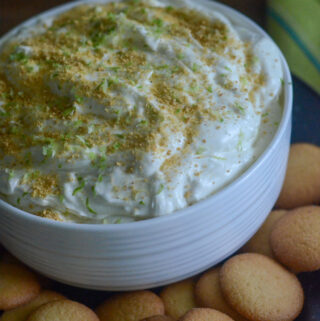 white bowl of key lime pie dip surrounded by vanilla wafers