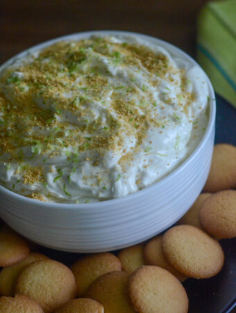 white bowl of key lime pie dip surrounded by vanilla wafers