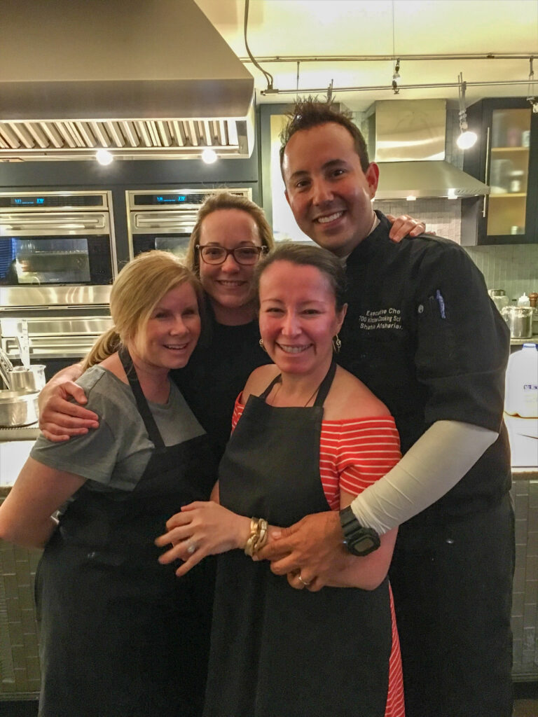 attendees pose with the chef at a Savannah cooking class at what the Mansion on Forsyth Park - now rebranded at Hotel Bardo Savannah