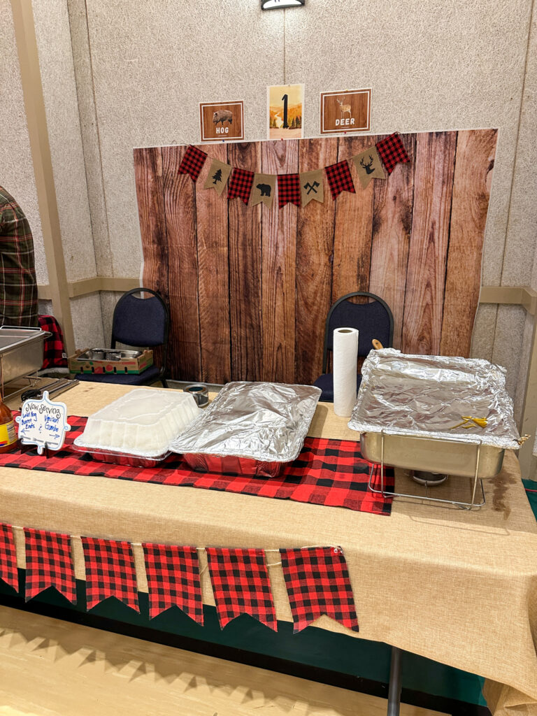 a booth set up for serving hog and deer recipes at a Wild Game Dinner