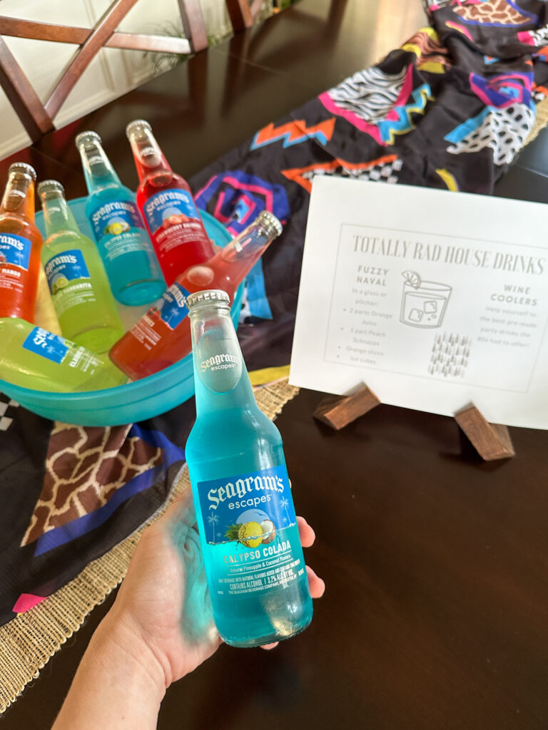 woman holds Seagram's Escapes in front of a printable 1980s drink menu