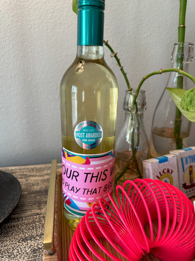 pink slinky with 1980s wine bottle and candy cigarettes for 1980s theme party decorations