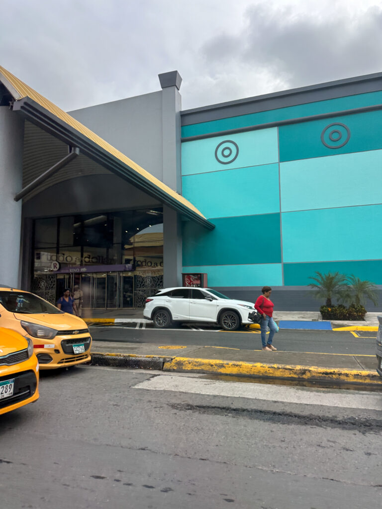 woman walks among taxis in front of Albrook Mall in Panama City, Panama