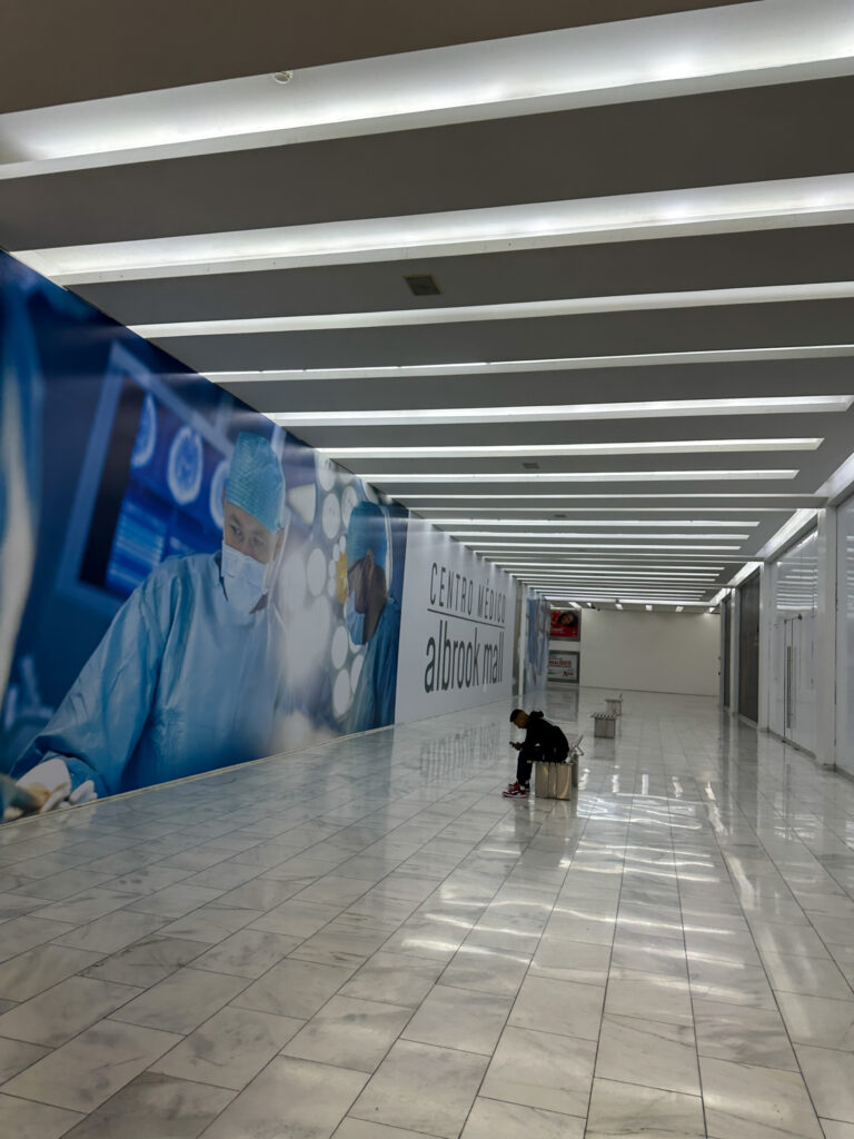 man waits in lobby of medical center at Albrook Mall in Panama City, Panama