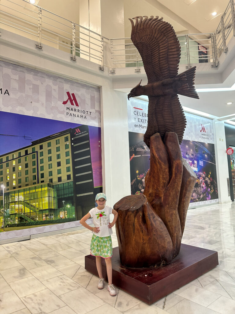 girl stands near Eagle statue in the Eagle Corridor of Albrook Mall