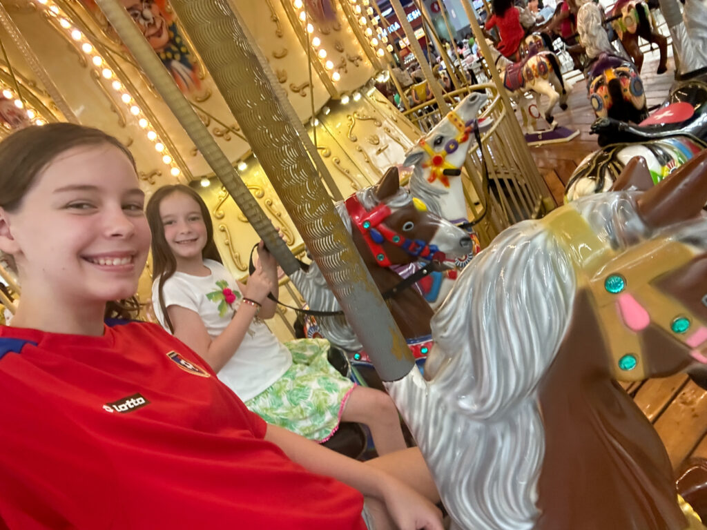 two girls on carousel horse