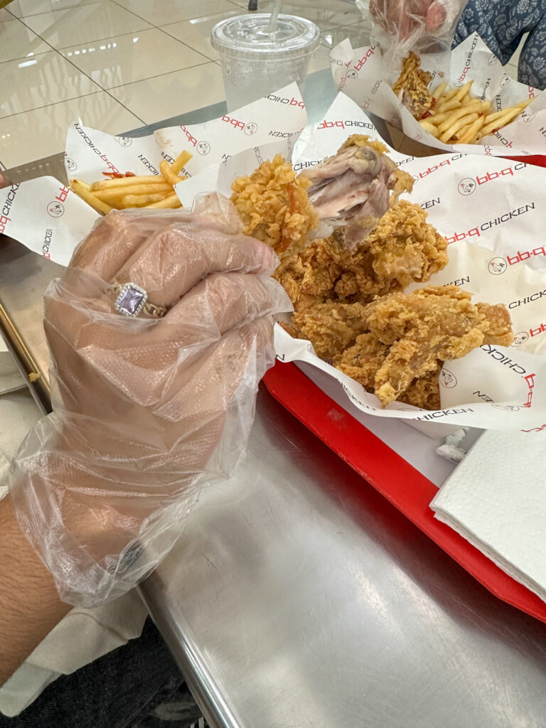 women eating fried chicken with plastic gloves at BBQ Chicken 