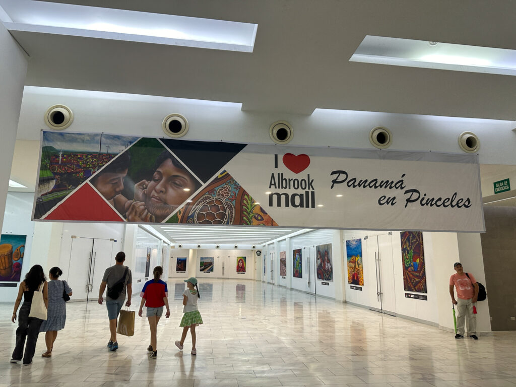 people walking under sign in Albrook Mall in Panama City, Panama