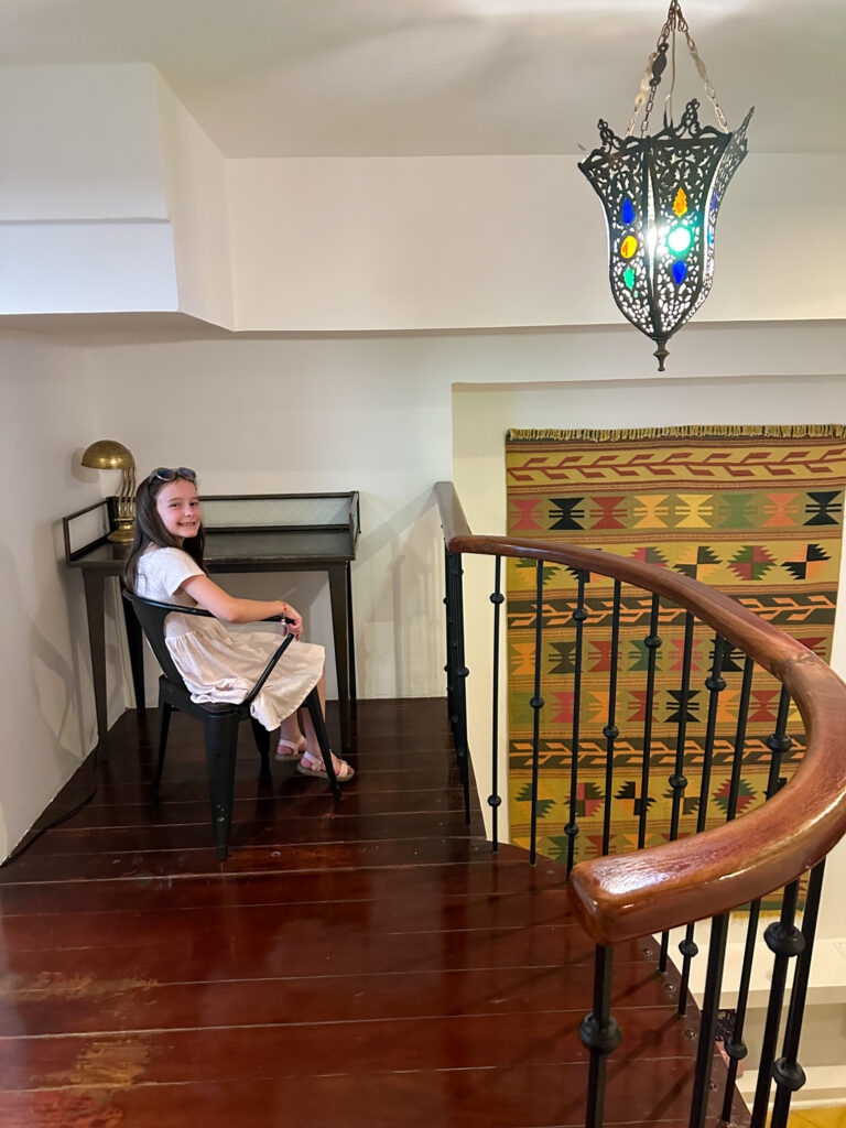 little girl sits in desk area of a loft bedroom in Casco Viejo apartment rental in Panama City