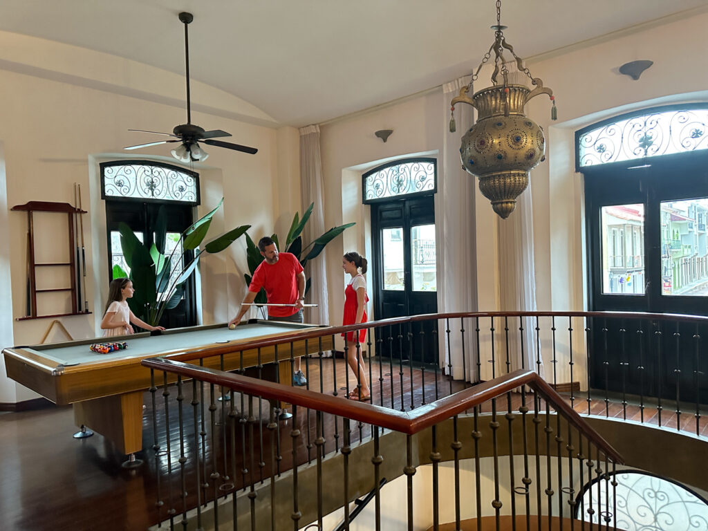 family plays pool in AmazINN Places Casco Viejo apartment rental pool table area in main room in Panama City, Panama