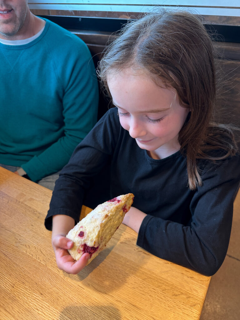 little girl holds scone at Stone Mill Bread and Cafe