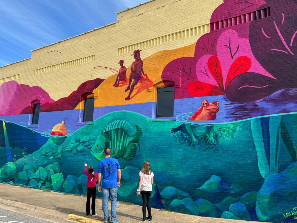 family looks at huge mural in downtown Springdale