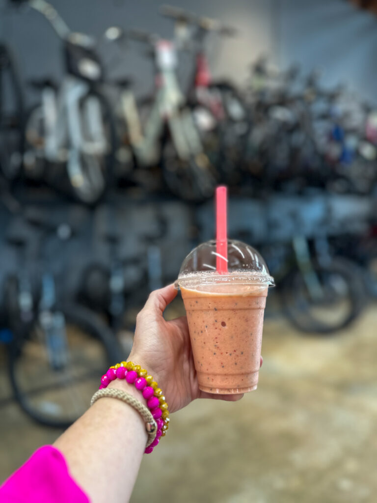 woman holds smoothie at Phat Tire Bike Shop and Trailside Coffee in Springdale, Arkansas