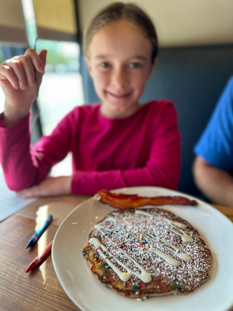 little girl with large confetti pancake at HomeGrown in downtown Springdale, Arkansas