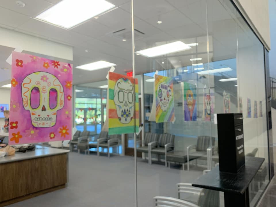 sugar skull artwork hanging on windows to a junior high office