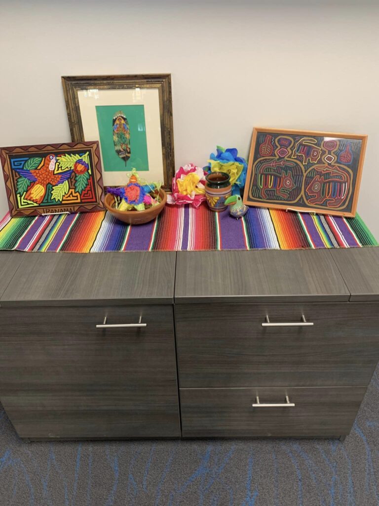 table of Hispanic art and pottery on serape for a collective Hispanic Heritage Month display