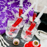 Halloween syringe cocktails on party table