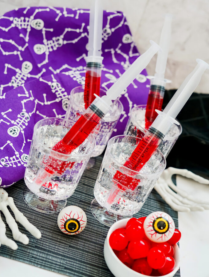 Halloween syringe cocktails on party table