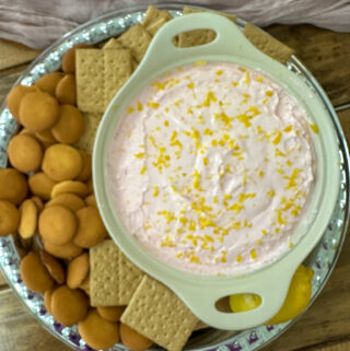 overhead view of pink lemonade dip with vanilla wafers and graham crackers on platter