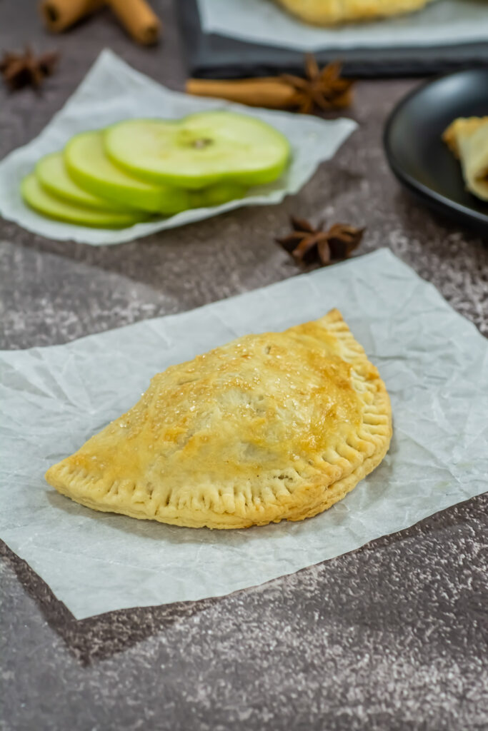 cinnamon apple empananadas on parchment paper