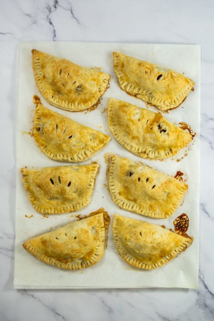 baked apple empanadas out of the oven on parchment paper