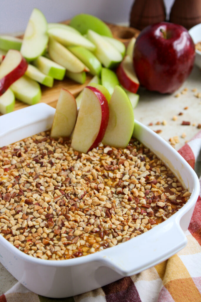 cream cheese caramel apple dip with fresh apple slices on plaid napkin