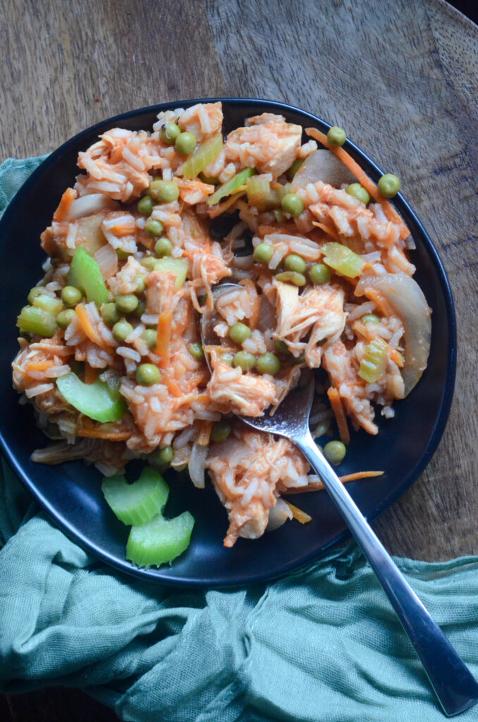 Pananamian arroz con pollo on a black plate with a spoon