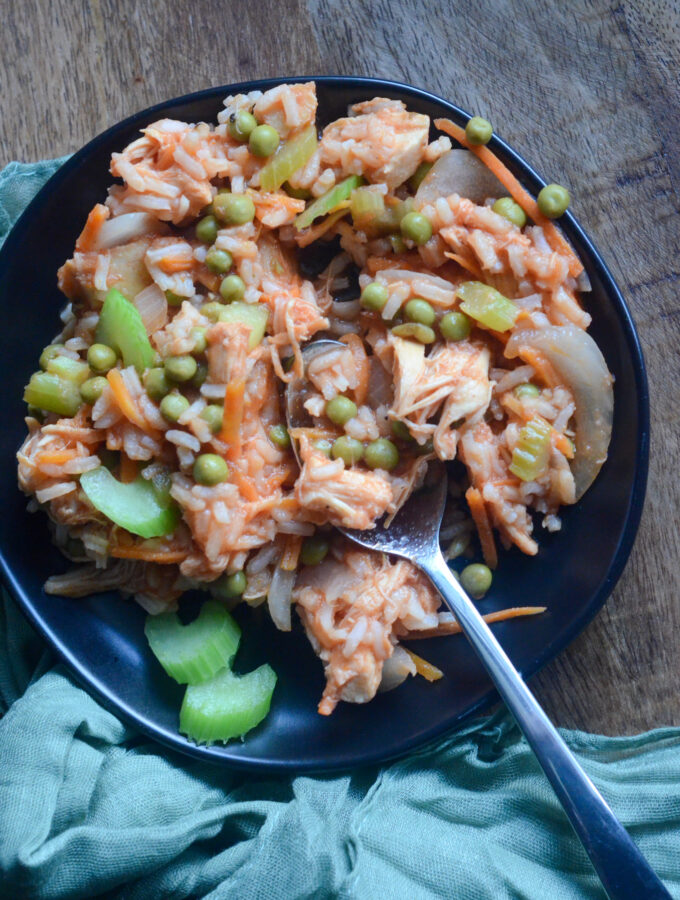 Panamanian arroz con pollo on plate with spoon and green napkin beside