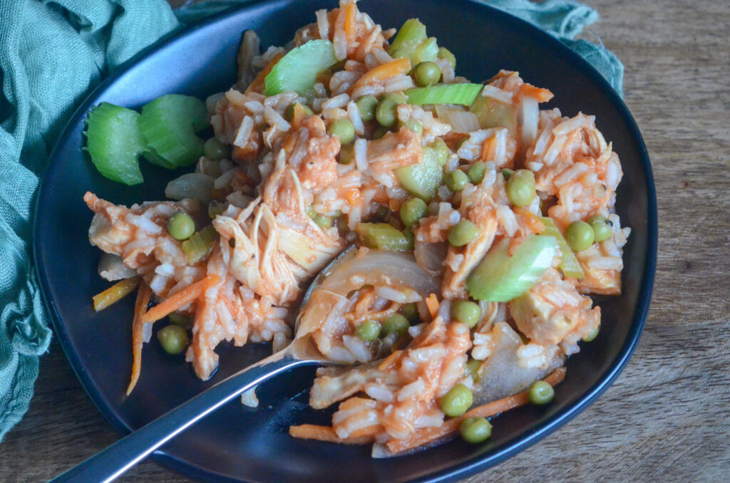 arroz con pollo Panameno - arroz con pollo Panamanian style on black plate with green napkin