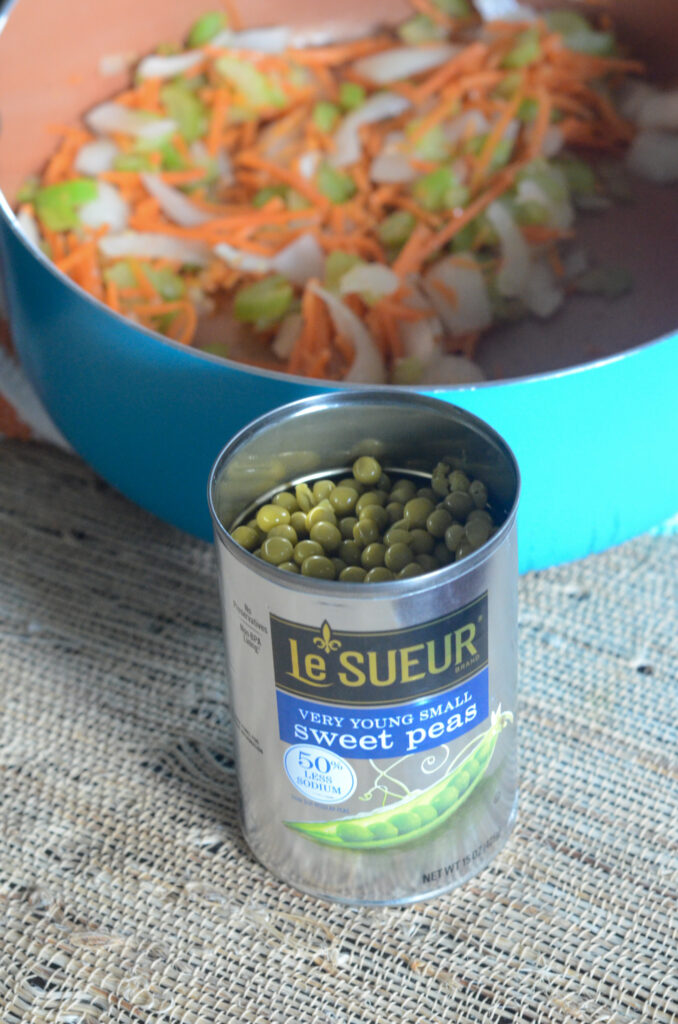 Le Sueur peas in can in front of pot of sauteed veggies