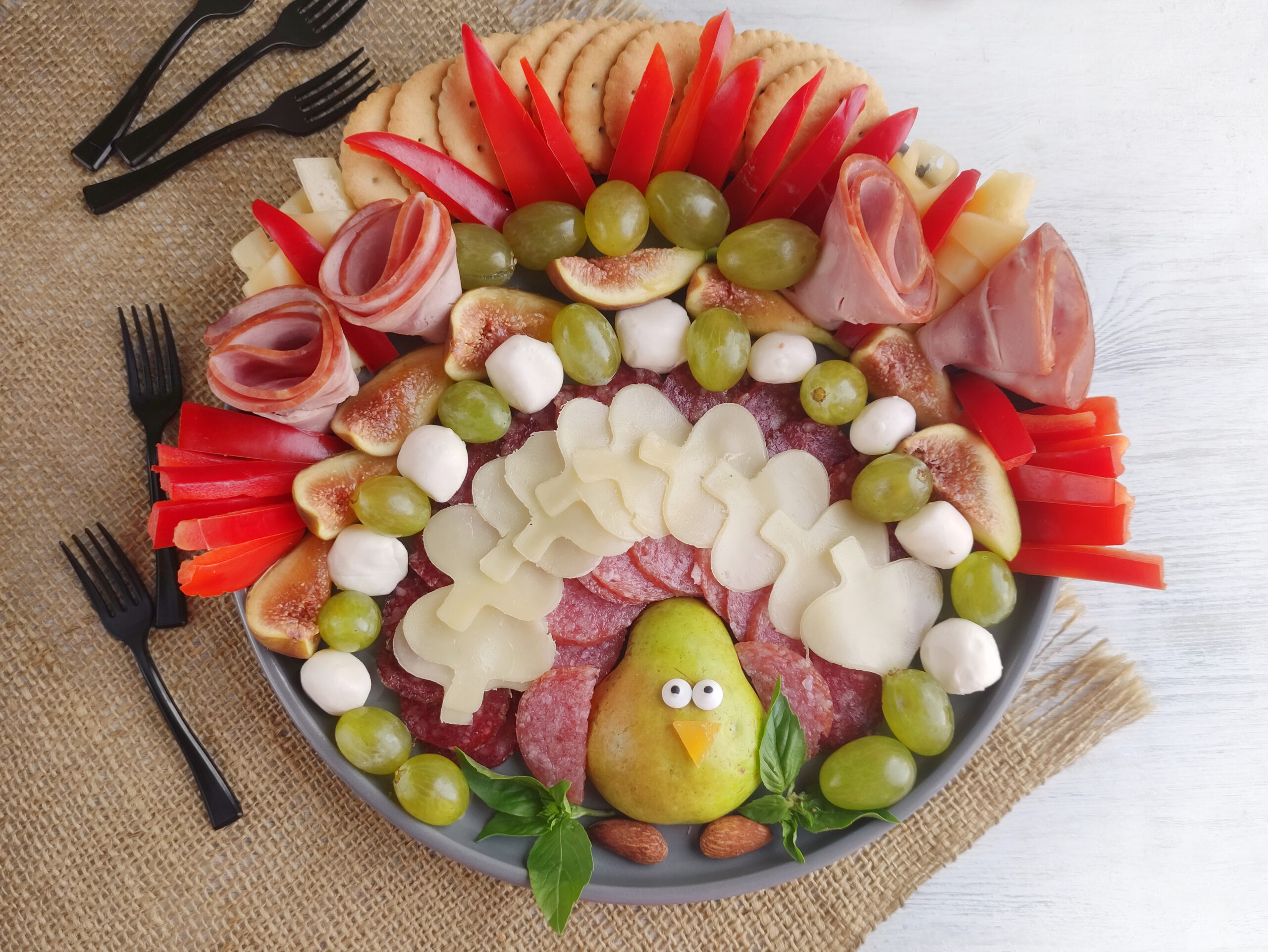 a Thanksgiving turkey meat and cheese tray with black forks