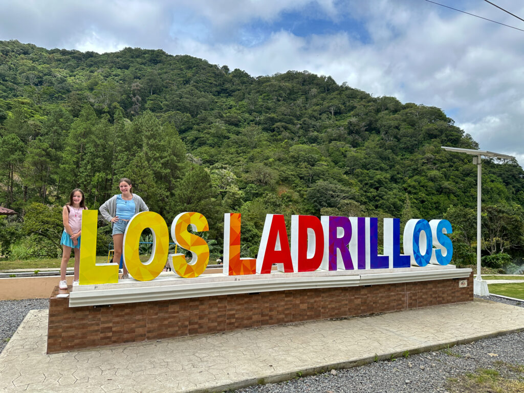 Los Ladrillos sign in Boquete, Panama with two girls posing