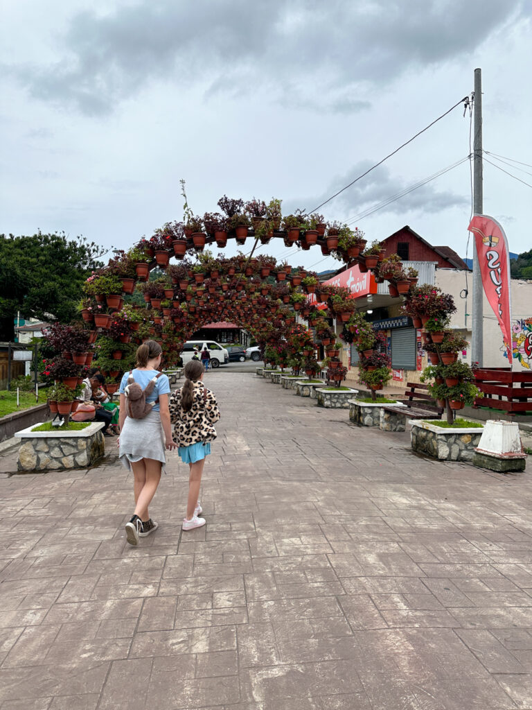 girls walking under flower bridge in downtown Boquete, Panama