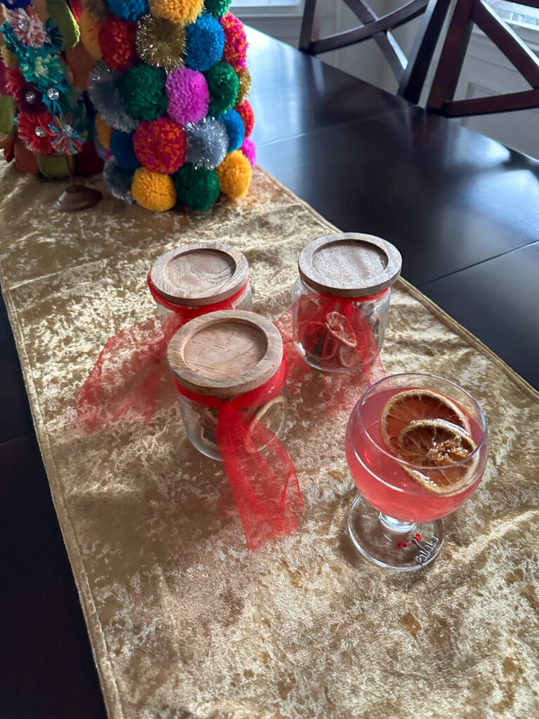 deyhdrated fruit gifts in jars with cocktail glass in front with dried orange slices on top