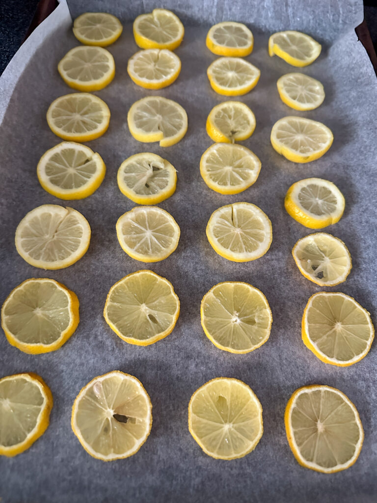 dehydrating lemon slices  on parchment paper for dehydrated fruit gifts for Christmas