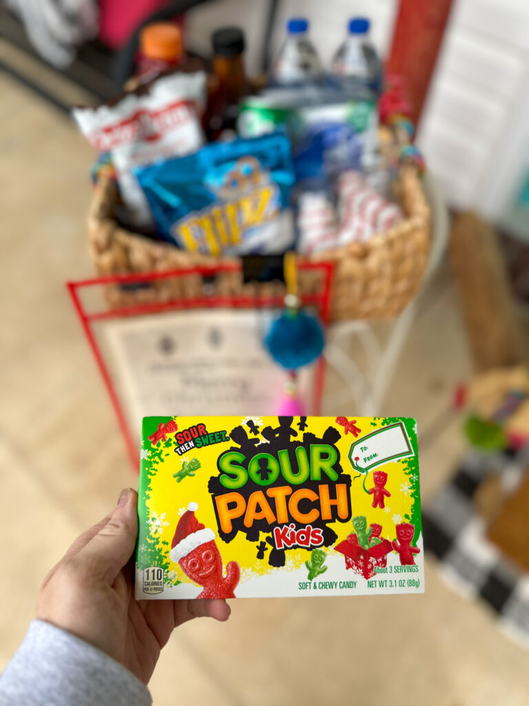 woman holds box of Sour Patch Kids