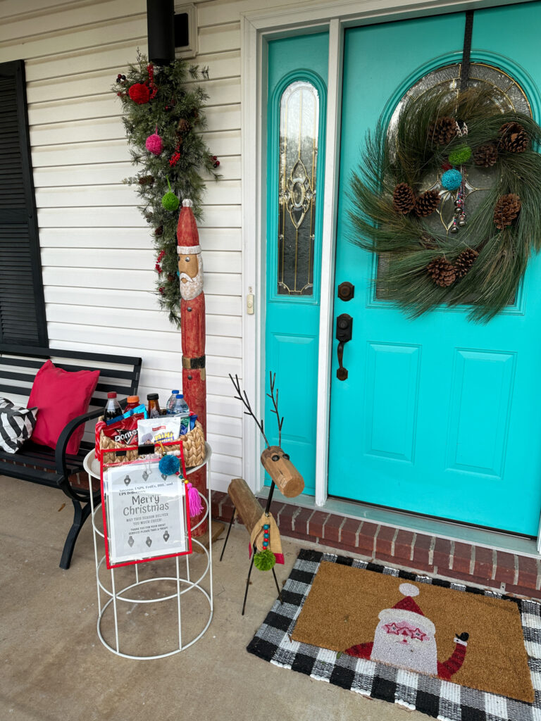 front porch decked for Christmas with delivery drivers snack table and printable sign