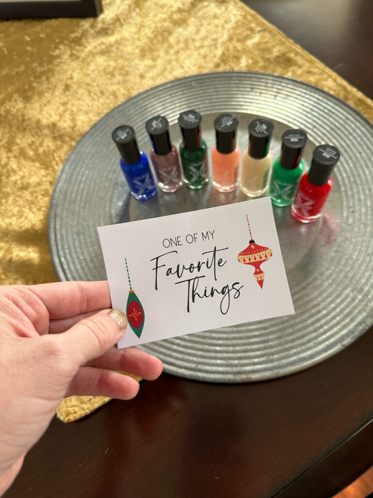 woman holds favorite things party printable in front of tray of nail polish