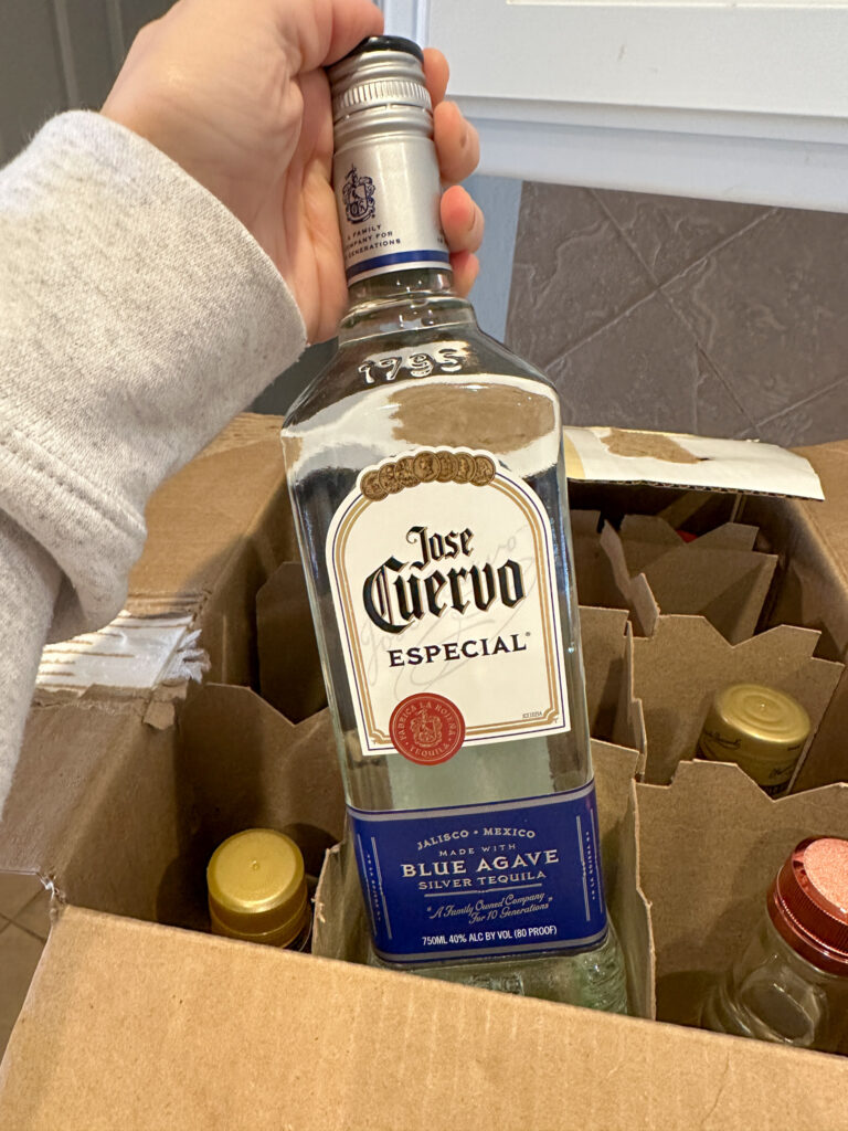 woman holds Jose Cuervo bottle as a home bar staple