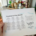 woman holds cocktail calendar of the month in hand