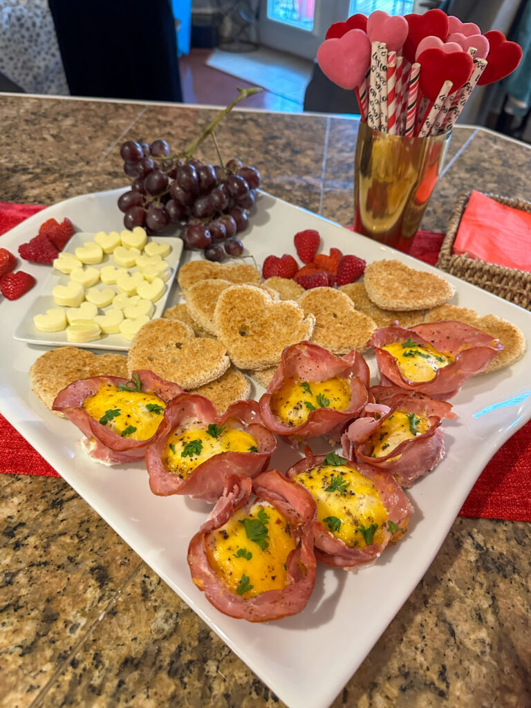 heart butter, heart toast, and ham egg cups on white serving tray for Galentine's brunch