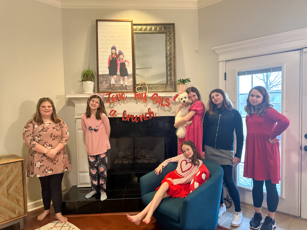 girls at a Galentine's brunch in front of "love my gals a brunch" sign