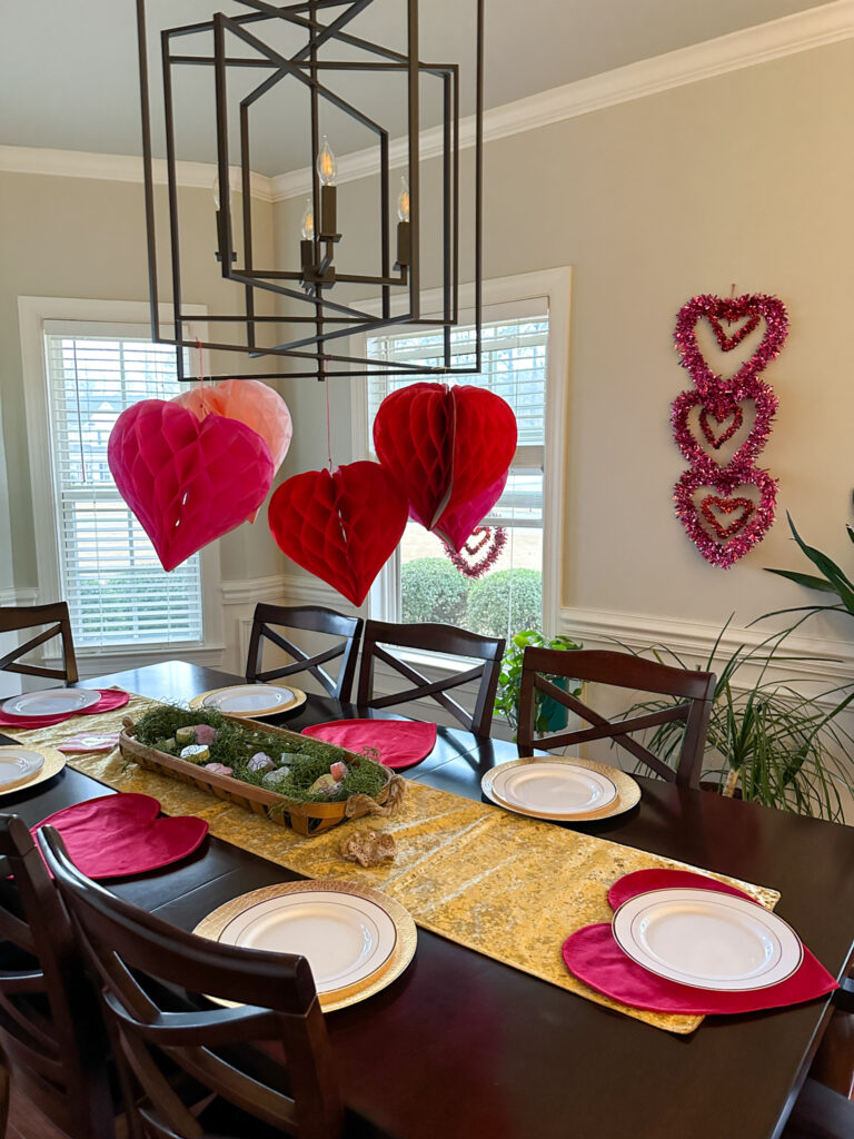 Galentine's brunch dining table with decorations dangling from the chandelier