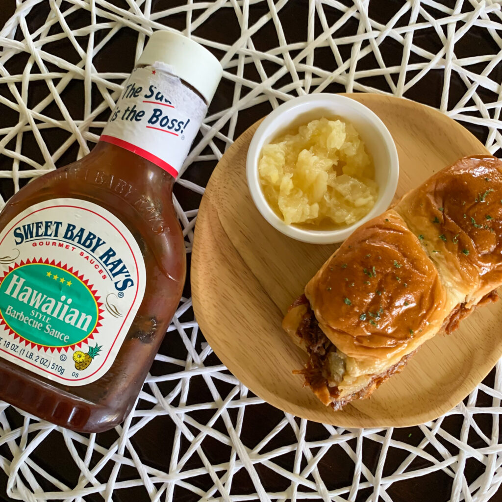 overhead view of pineapple pulled pork sliders with Sweet Baby Ray's Hawaiian Barbecue Sauce on white placement