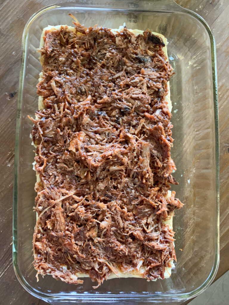 meat on top of bread in glass pan